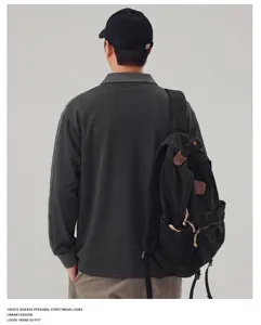 Details van heren lang mouw polo sweatshirt met kleurblok patchwork en halve sluiting.