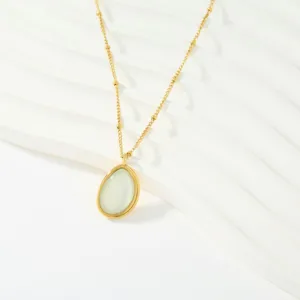 Primer plano detallado del collar con colgante de circonita blanca y cadena de cuentas doradas.