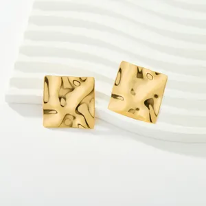 Orecchini geometrici quadrati dorati con superficie ondulata testurizzata. Design chic.