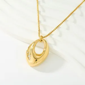 Detailed close-up view of the 18k gold plated hollow teardrop pendant necklace with stones.