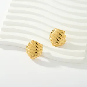 Primer plano de pendientes geométricos acanalados de acero inoxidable bañado en oro 18K, elegante.