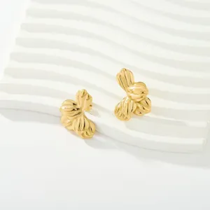 Exquisitos pendientes de tuerca florales irregulares de acero bañado en oro 18k, detalle.