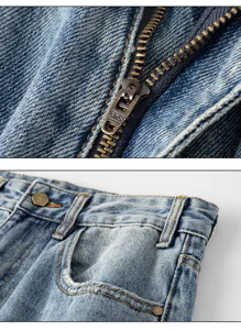 Detailed close-up view of distressed denim jeans showing zipper, coin pocket and hardware.
