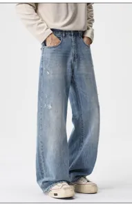 Detailed view of men's vintage distressed light blue loose denim jeans with wide leg style.