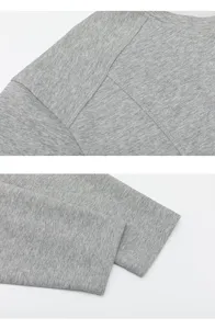 Grey long sleeve t-shirt detail showing shoulder patchwork and clean cuff stitching.