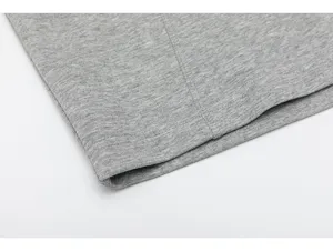Close-up of grey heavyweight long sleeve t-shirt fabric showing neat stitching and texture.