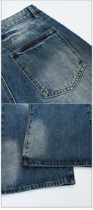 Vintage washed denim jeans detail close-up showing back pocket and hem stitching style.