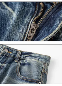 Close-up detail of vintage distressed blue denim jeans showing zipper and metal button.