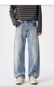 Detail view of men's light blue paint splatter straight-leg denim jeans with classic styling.