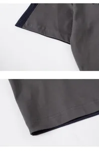 Dettaglio ravvicinato di cuciture su maniche e orlo di t-shirt grigia pesante con inserti.