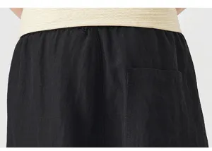 Detailed view of black loose Tencel linen shorts back pocket and elastic waistband fabric.
