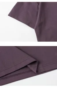Λεπτομέρεια σκούρο μοβ t-shirt που δείχνει προσεγμένη ραφή σε μανίκια και στρίφωμα.