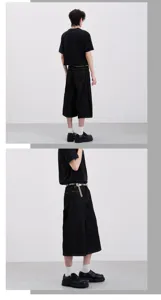 Detail view of men's black wide-leg cropped denim jeans, showing loose fit and street style design.