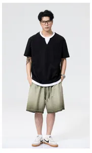 Casual detail of loose short sleeve polo shirt and gradient shorts worn by male model.
