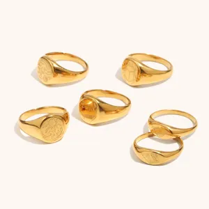 Detalles en primer plano de anillos de sello de acero inoxidable bañado en oro con motivos marinos.