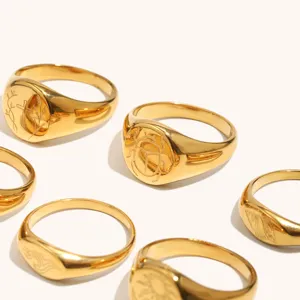 Detalles anillos sello de acero inoxidable bañado en oro con patrón marino grabado.
