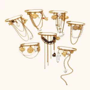 Gros plan detaille de plusieurs broches epingles de surete en acier dore avec perles et chaines.