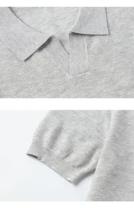 Primo piano dettagliato del colletto e dei polsini del polo in maglia grigio chiaro.