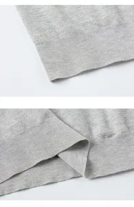 Primo piano di tessuto a maglia grigio, consistenza morbida e orlo a coste per abbigliamento estivo.
