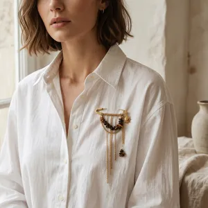 Élégante broche pampille dorée avec pendentif soleil et perles œil de tigre chic.