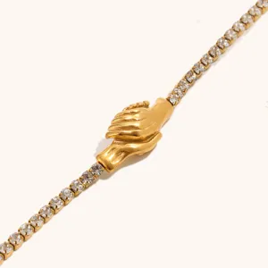 Dettaglio in primo piano del bracciale tennis in acciaio inossidabile dorato con ciondolo.