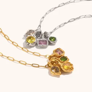 Close-up van trendy onregelmatige metalen hangkettingen met meerkleurige edelstenen.
