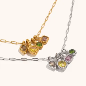 Detailweergave van een roestvrijstalen ketting met meerdere bedels en kleurrijke edelstenen.