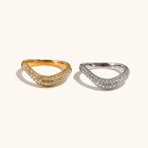 Close-up of stainless steel irregular V-shaped pave rhinestone wave rings in gold and silver finish.