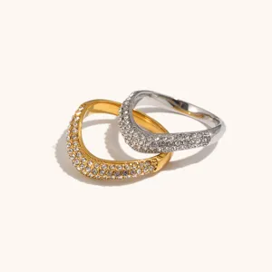 Close-up detail of double irregular V-shaped pave rhinestone rings in gold and silver tones.