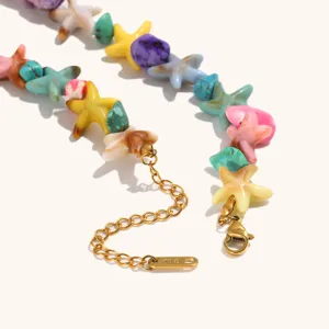Dettaglio collana con perline a stella Marina colorata e chiusura in acciaio dorato 18k