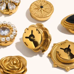 Close-up detail of 18k gold-plated stainless steel floral and pearl snap buttons for fashion apparel.