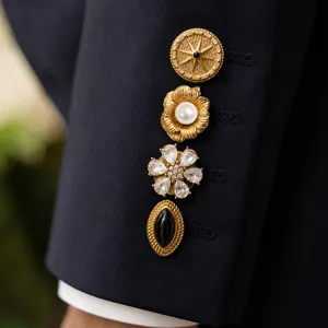 Close-up detail of luxury gold-plated suit buttons with stars, pearls, and zircons.