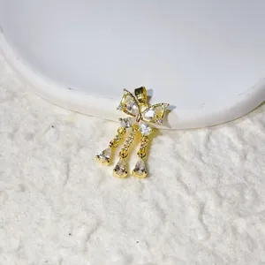 Close-up detail of a delicate gold-plated butterfly pendant with shimmering zircon drops.