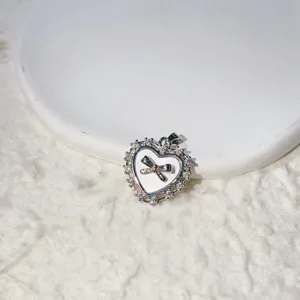 Close-up view of heart-shaped pendant with sparkling micro-inlaid cubic zirconia and bow detail.