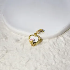 Exquisite micro-paved zircon heart pendant detail in gold-plated copper with cute floral charm.