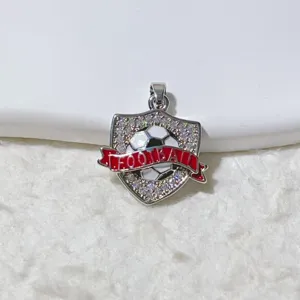 Primo piano dettagliato del ciondolo scudo da calcio con strass e nastro rosso per gioielli diy.