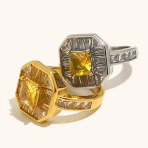Detalle de primer plano de anillos geométricos octogonales con piedras amarillas y transparentes.