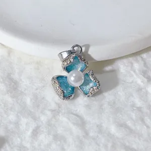 Nahaufnahme eines blauen Glitzer-Blumenanhängers mit Perle und funkelndem Zirkon.
