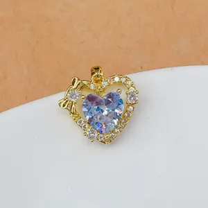 Gold heart pendant charm with sparkling cubic zirconia and cute bow, detailed jewelry accessory.