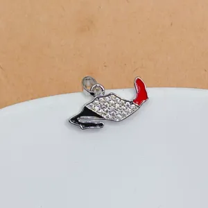 Gros plan détaillé du pendentif carte argenté avec des strass scintillants et de l'émail.