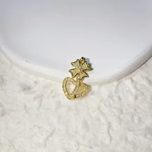 Close-up detail of a gold-plated pave cubic zirconia bow and dual heart pendant accessory.