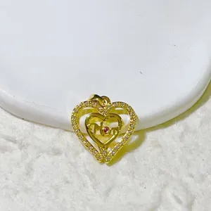 Close-up of a gold double heart pendant with pavé stones and Mom text detail for jewelry.
