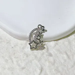 Primo piano dettagliato del ciondolo argentato a luna e stella con strass e scritta MOM.