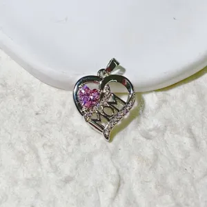 Detailed close-up of heart pendant with pink cubic zirconia and mother text inlay.