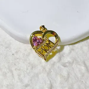 Close-up detail of gold heart mom pendant with pink crystal and micro-pave zirconia stones.