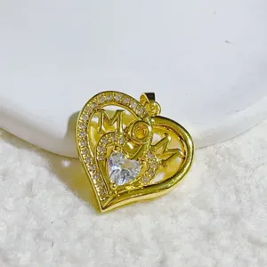 Gold heart pendant with sparkling clear stones and MOM engraving, exquisite jewelry detail view.