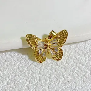 Dettaglio pendente gioiello farfalla placcato oro, primo piano pietre zircone lucide