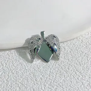 Detailaufnahme eines oeffnenden Herz Engel Fluegel Kupferanhaenger mit Zirkonia Steinen.