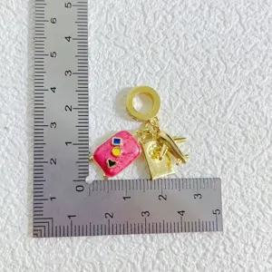 Gold plated copper DIY charm pendant set featuring travel theme airplane and pink suitcase.