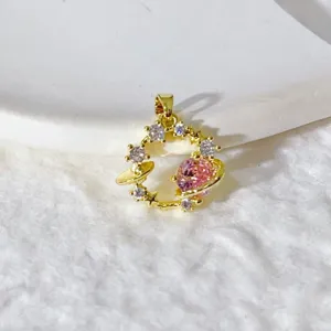 Primo piano di uno splendido ciondolo pianeta placcato in oro con pietre di zirconi cubici.